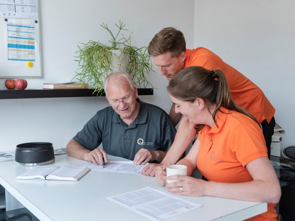 drie mensen in overleg aan tafel