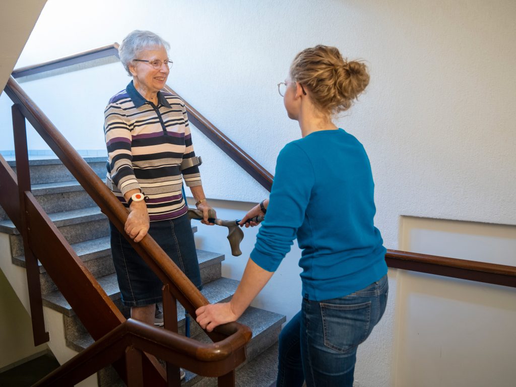 Mevrouw trap af samen met fysiotherapeut