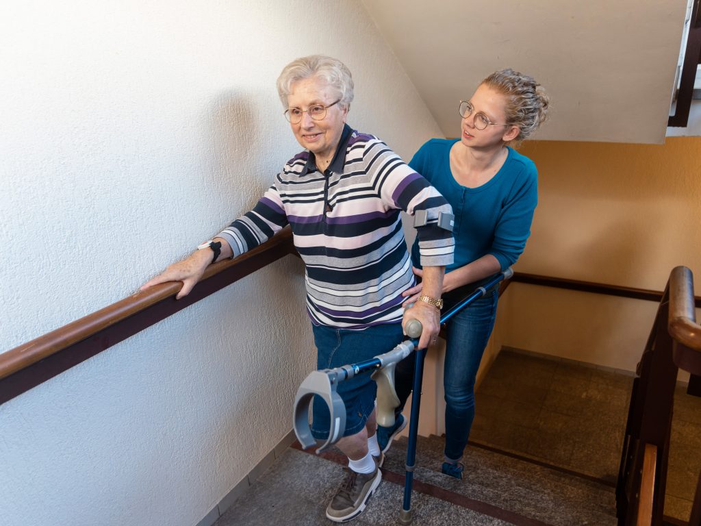 Mevrouw trap op lopen met stokken