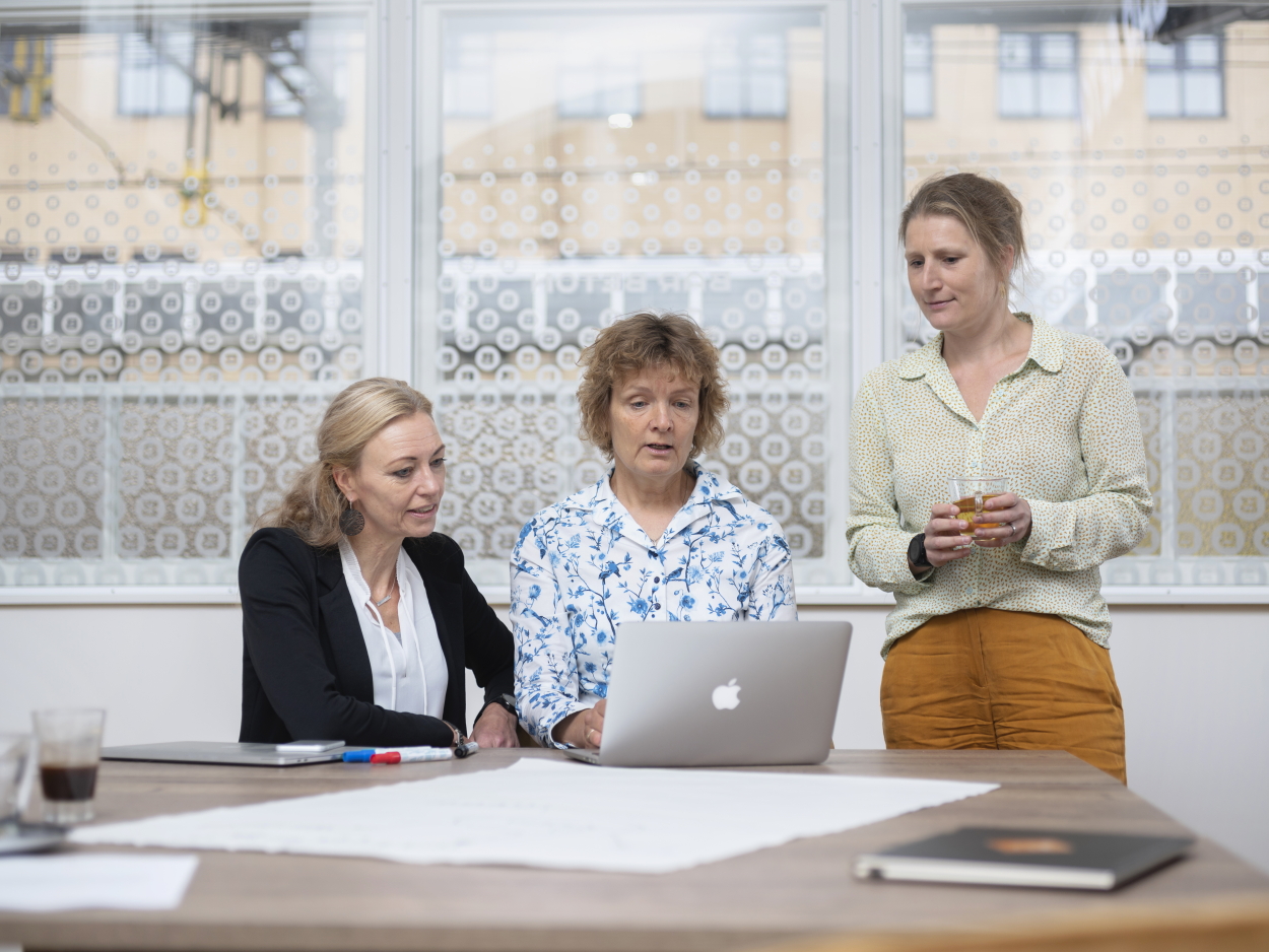 Drie mensen kijken op computerscherm