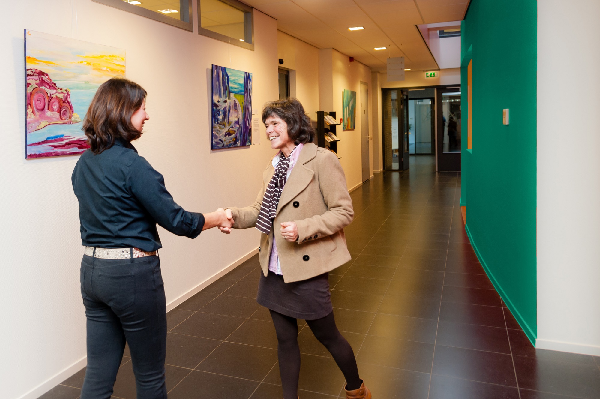 foto van 2 mensen die elkaar de hand schudden