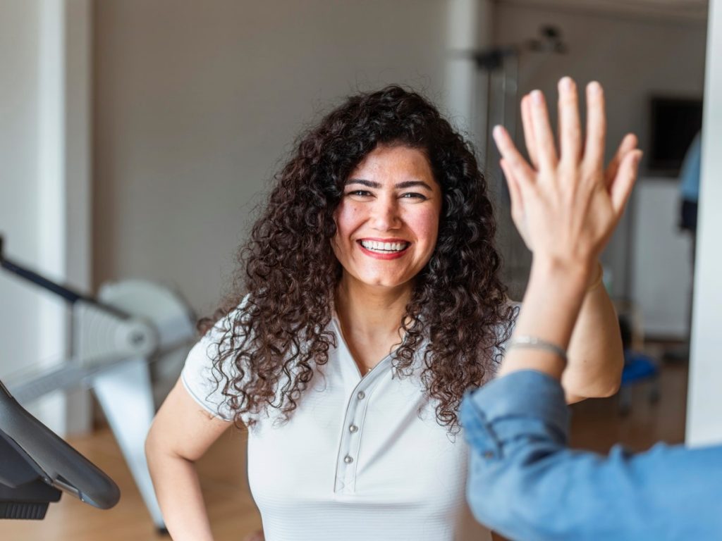 vrouw met krullen geeft high five