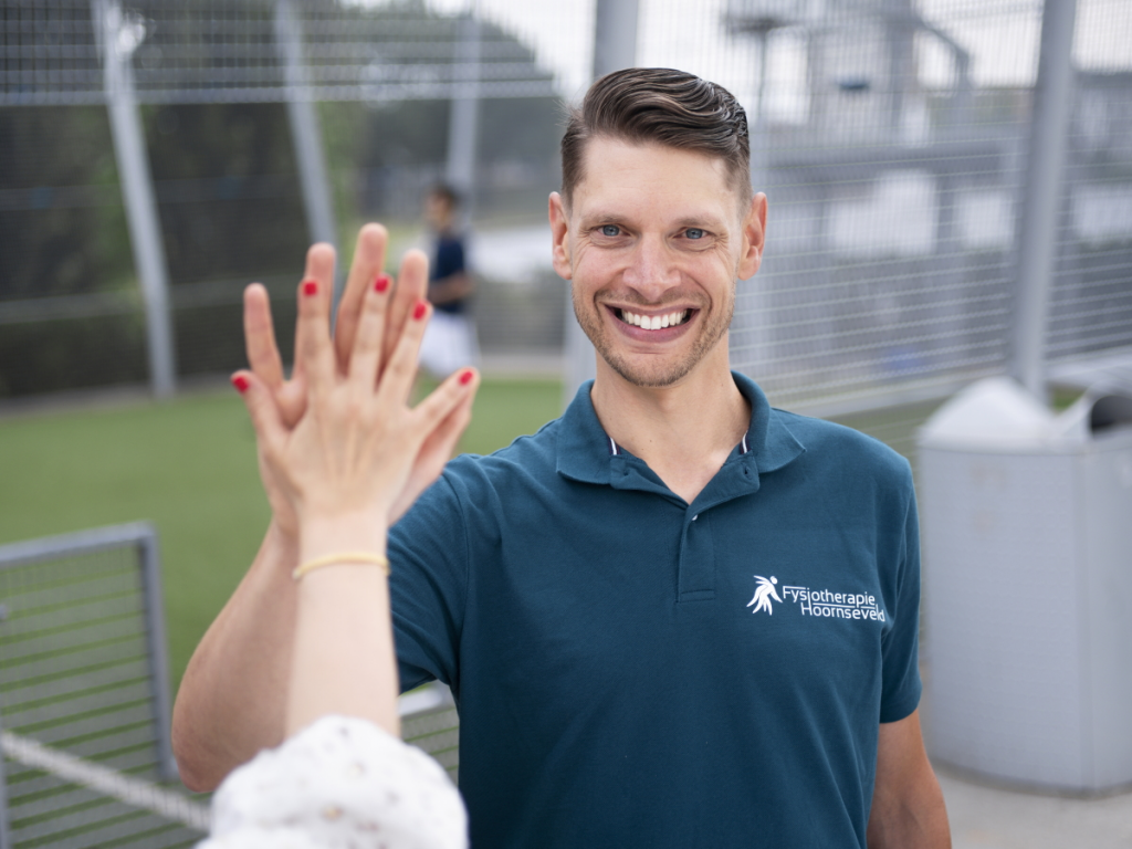 Mannelijke jonge fysiotherapeut geeft high five