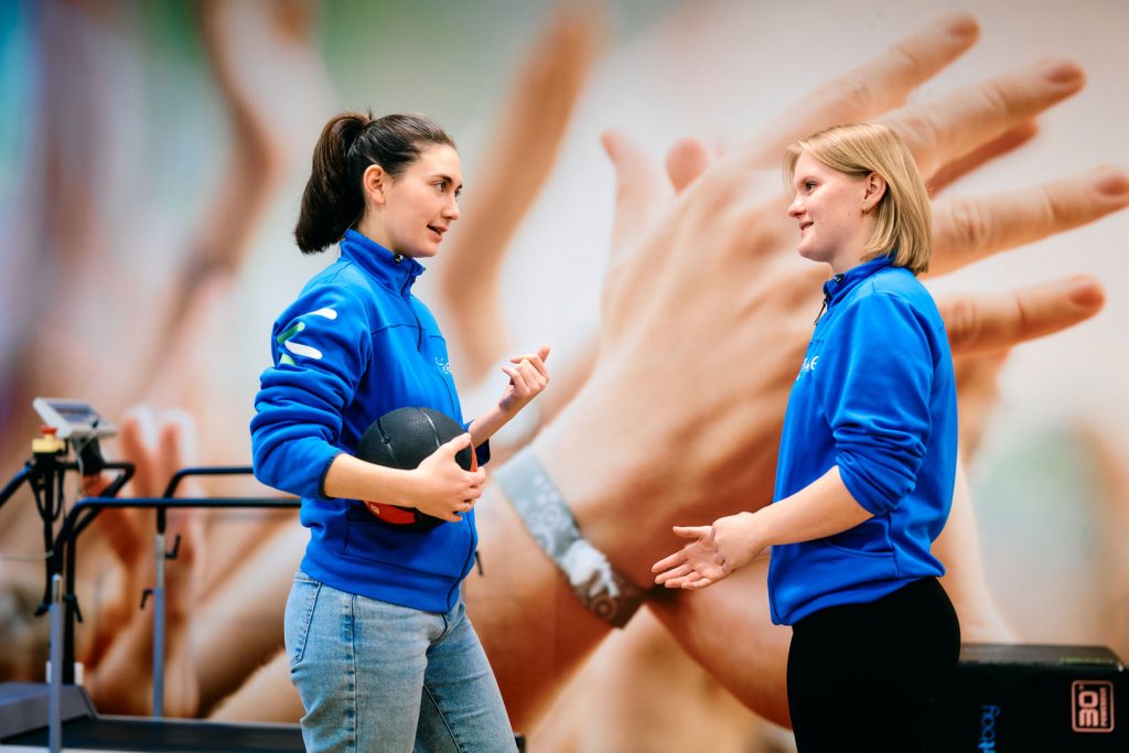 Fysios in gesprek met een bal in de hand