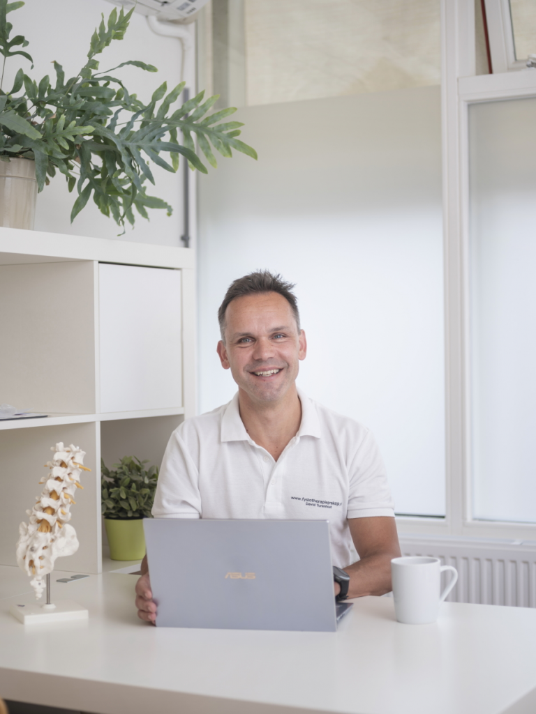 Een persoon achter zijn bureau met laptop