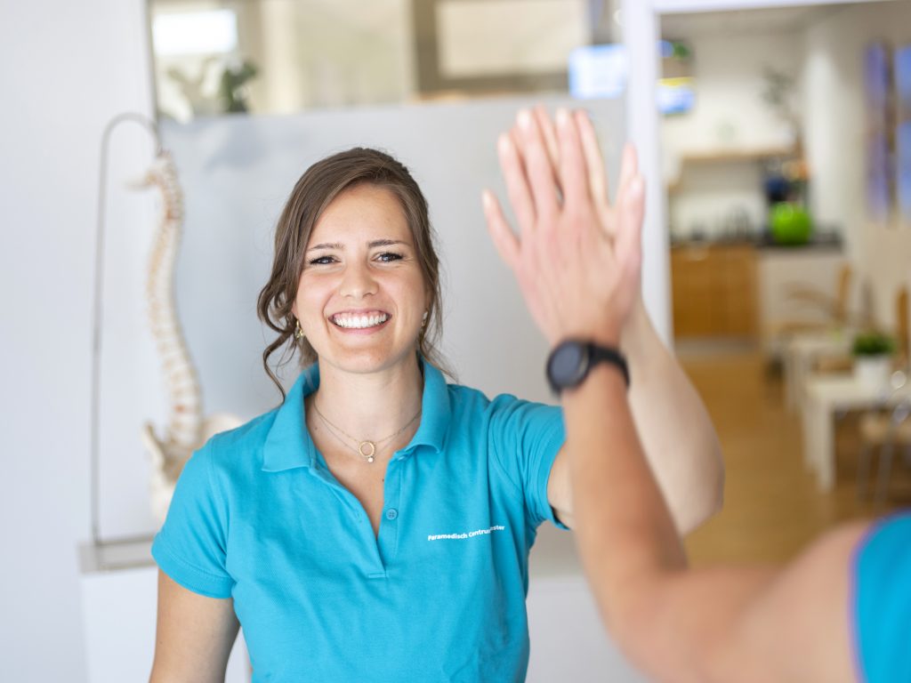 vrouw met blauw shirt geeft highfive