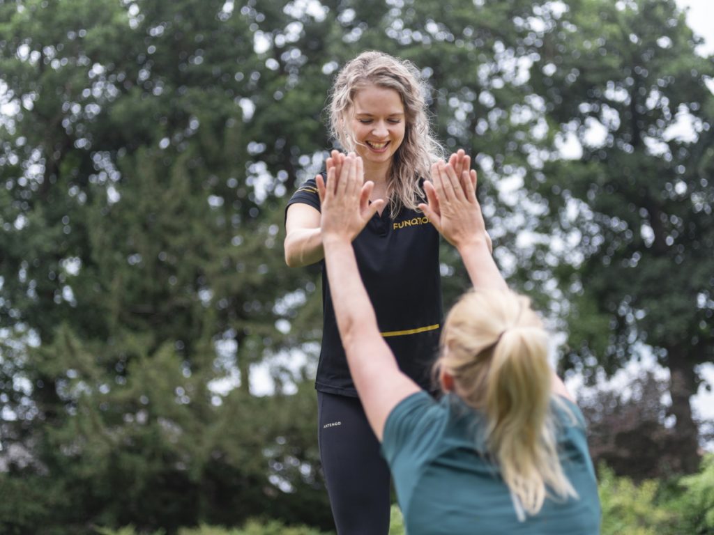 fysiotherapeut en vrouw houden handen tegen elkaar