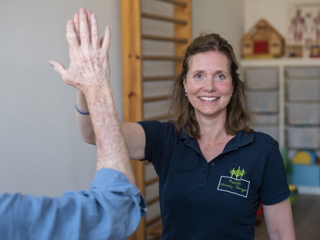 Vrouw voor klimrek geeft highfive